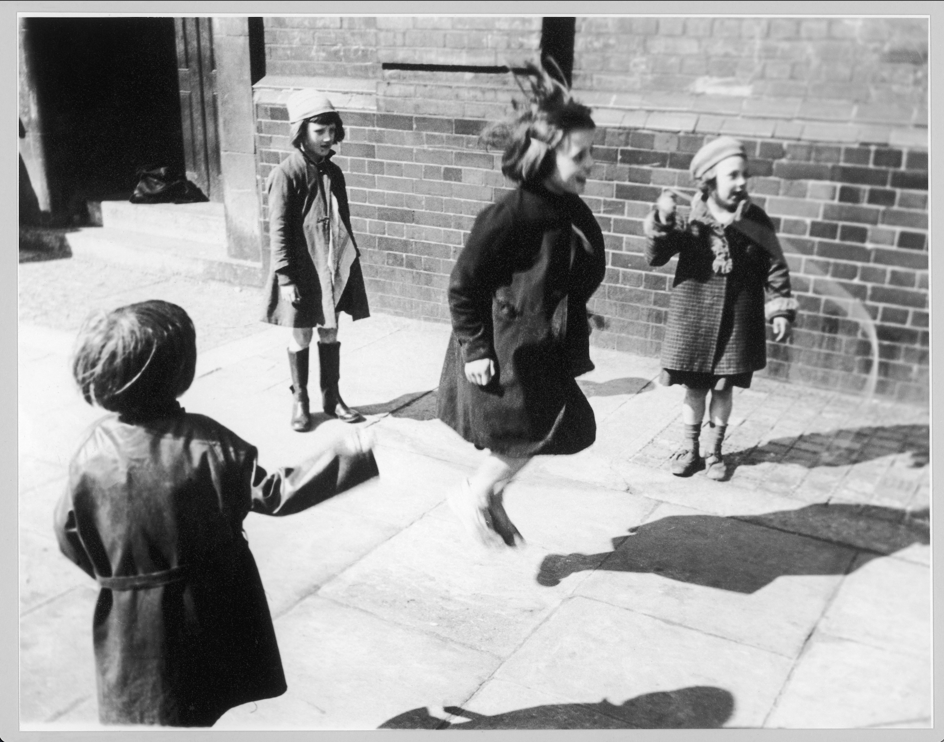 Monck, Girls skipping rope, East London, mid-1930s Black and white photo of girls playing jump rope in the street